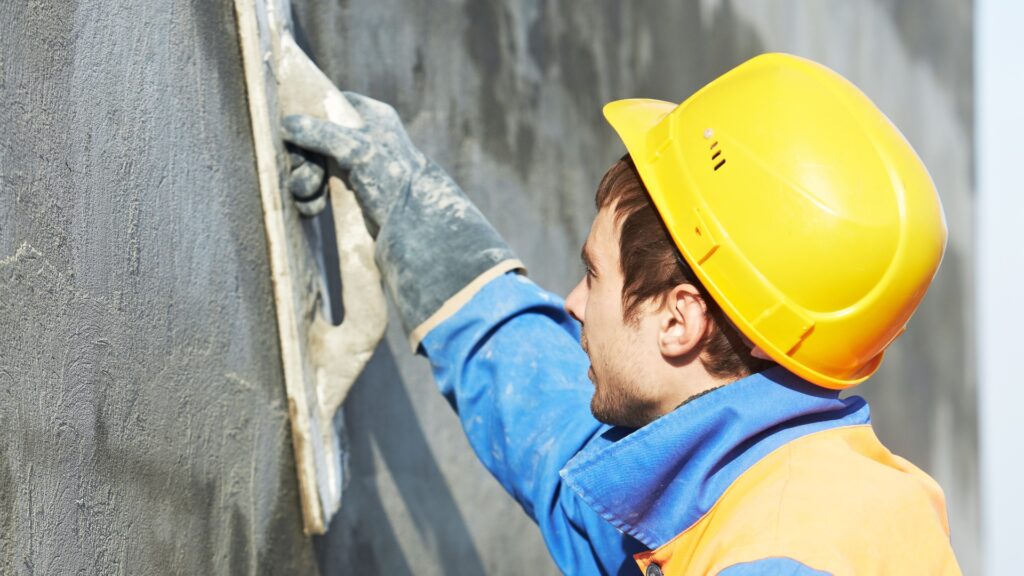 Arbeiter bei Putzarbeiten an der Fassade